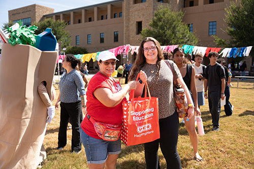 HEB representative handing student a bag