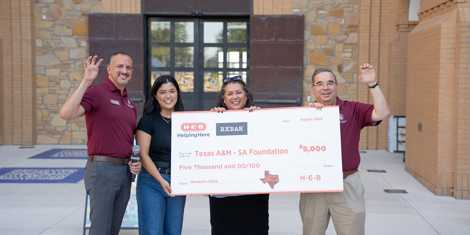 Dr. Ochoa and three other people in front of CAB holding donation check